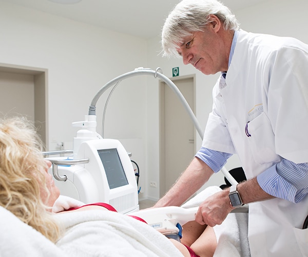 Plastisch chirurg behandelt patiënte in de Duinbergen Clinic met geavanceerde apparatuur